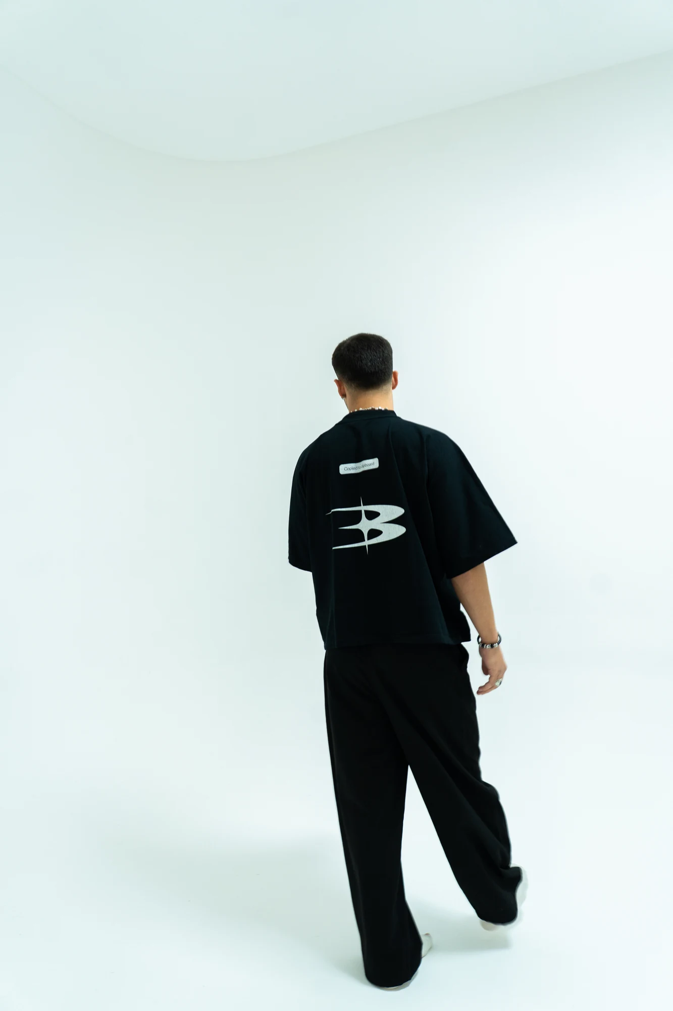 David Rosado de espaldas en un estudio, vestido con ropa de Nothing Bound.
